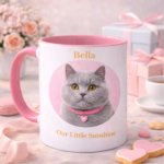 Personalised pink handle cat mug featuring a grey cat portrait, the name Bella, and the phrase Our Little Sunshine