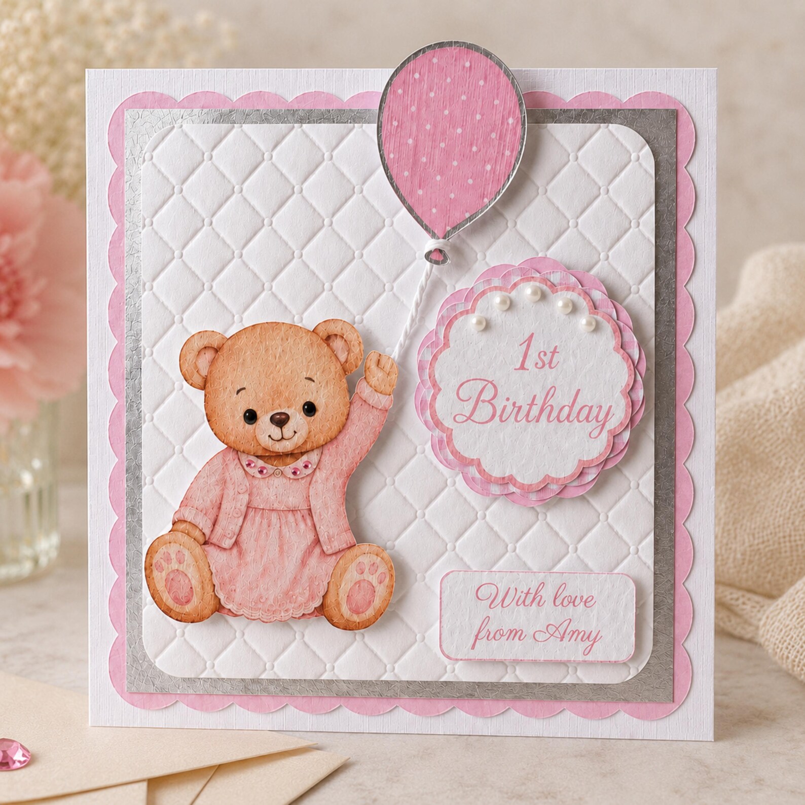 Close-up of personalised baby girl first birthday card with pink teddy bear details